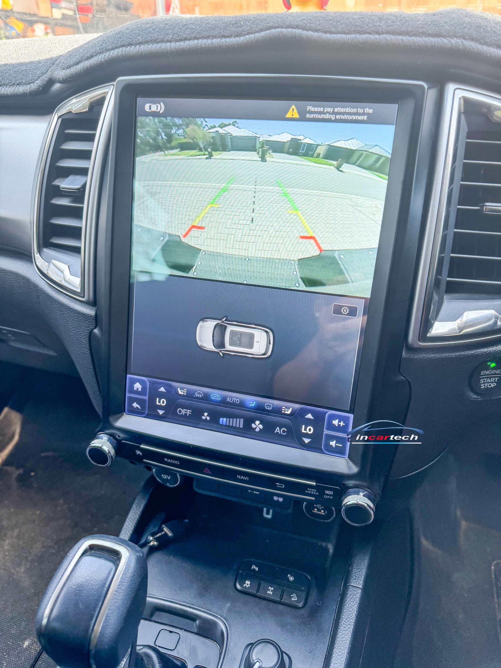 Car dashboard with a navigation system displaying a rearview camera view.
