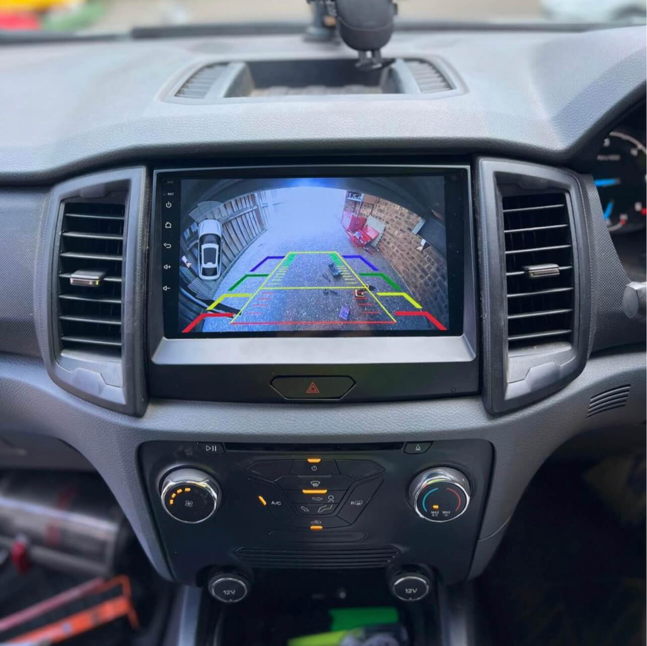 Car dashboard with a navigation screen displaying a rearview camera view.